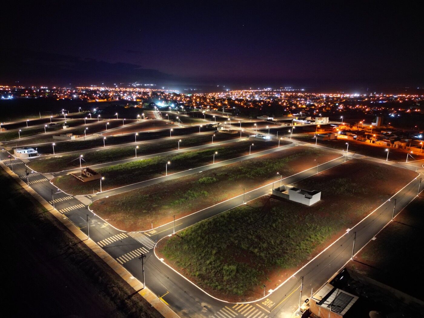 Vista do loteamento Royal Park ao entardecer, com iluminação pública em LED